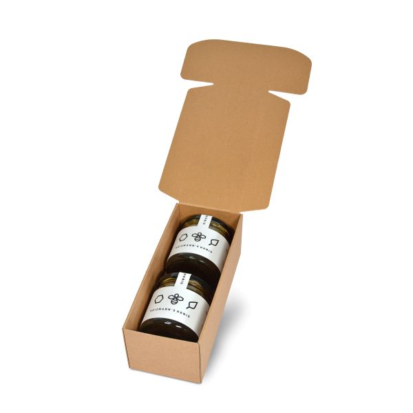 Geschenkbox aus neutralem Kraftpapier in länglicher Form geöffnet mit Deko.